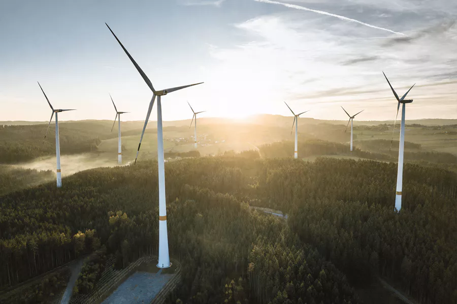 A large wind farm on a European mountain landscape, representing sustainable infrastructure compliant with the EU Taxonomy.